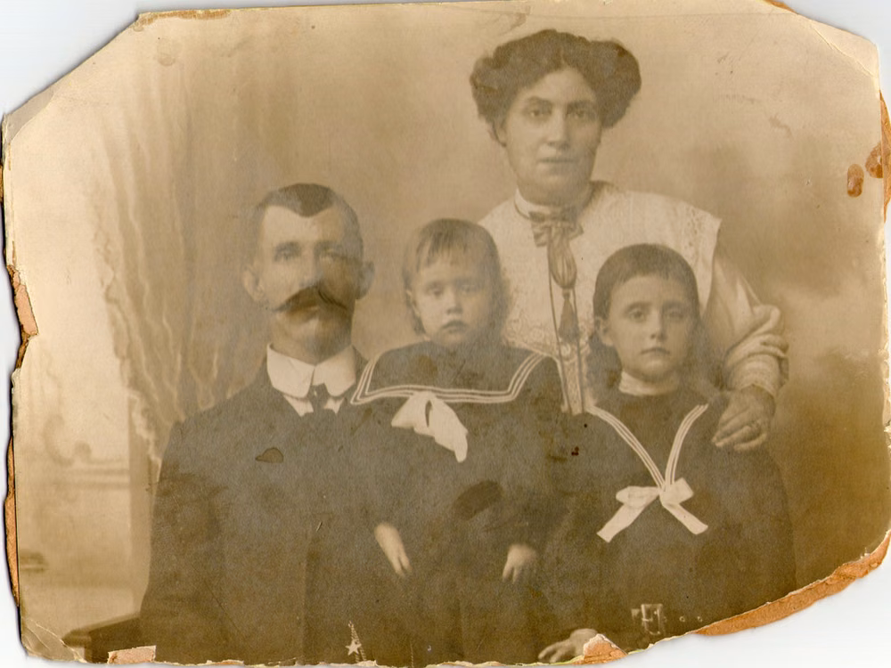 1900s family portrait browned with age and with crumbling edges